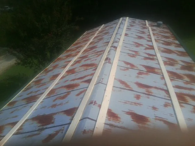 Rusted metal roof panels with new wood purlins before replacement — Storm Damage Roof Repair in Luttrell by Roofing Brothers