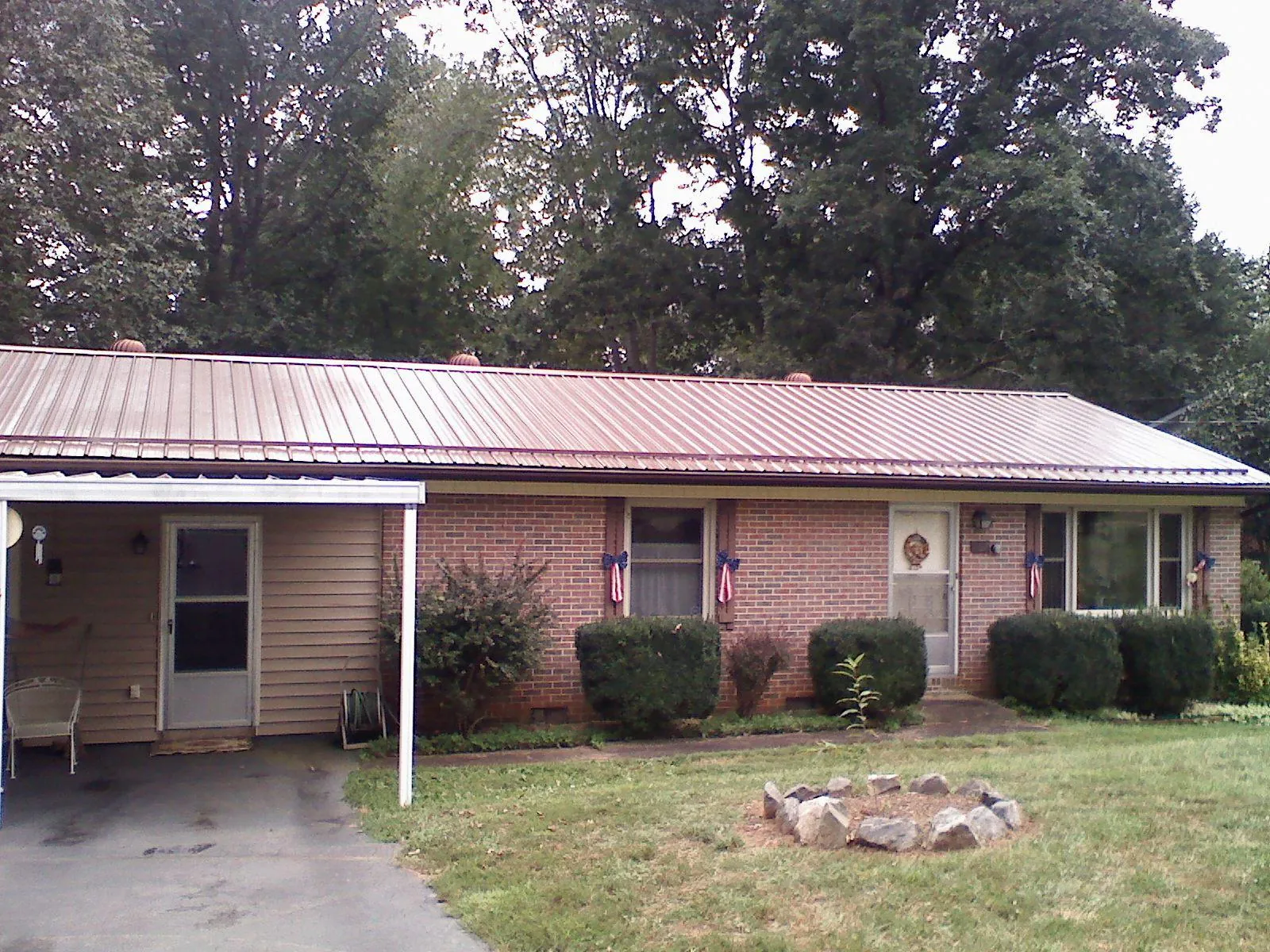 Bronze metal roof and carport on a brick ranch home — Roof Repair work by our crew in Luttrell