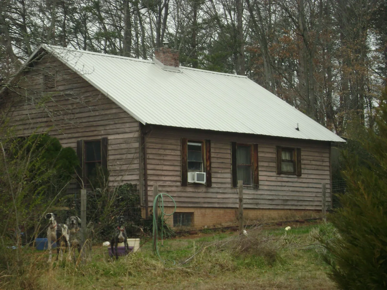 White metal roof on an old wood sided farmhouse, from a Metal Roof Installation job in Luttrell